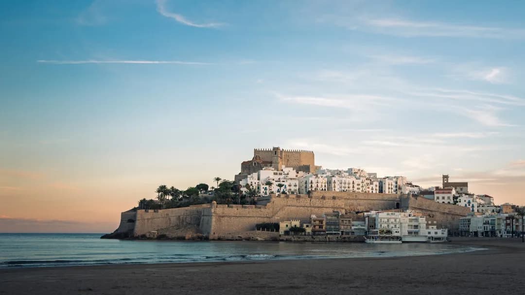 White buildings on a cliff overlooking the sea.