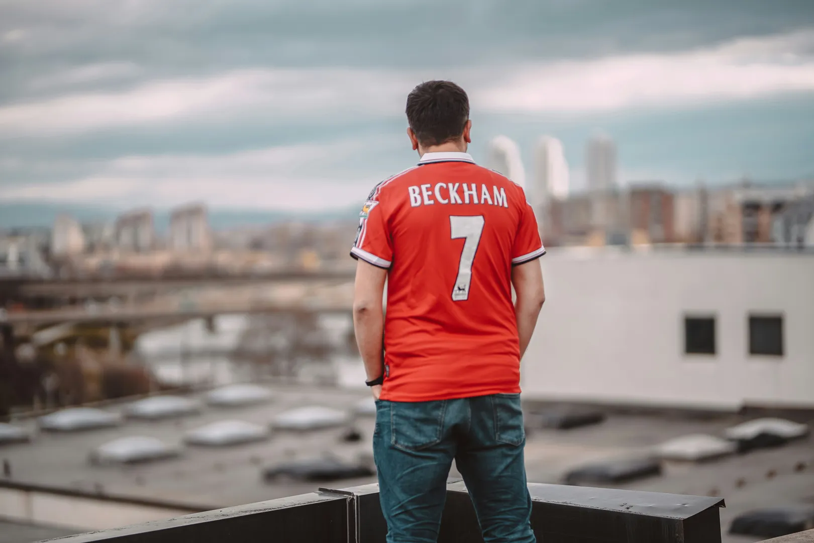 Man in a footbal shirt with Beckham name on it.